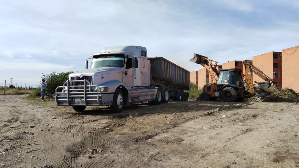 Tractocamión con remolque y maquinaria en un terreno